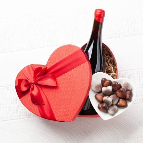 Valentines day heart gift box with wine and chocolate. Top view flat lay with copy space